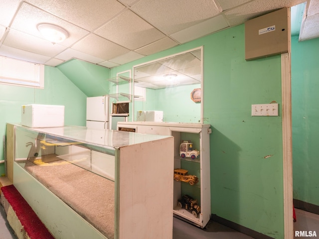 kitchen with a paneled ceiling and white appliances