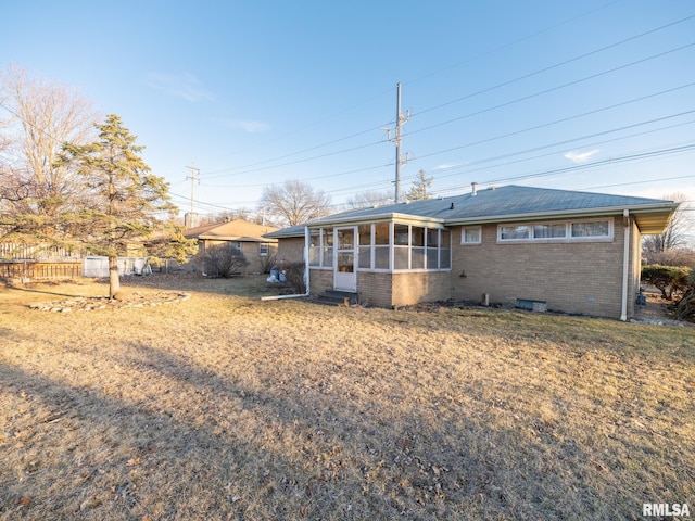 exterior space featuring a sunroom, brick siding, and fence