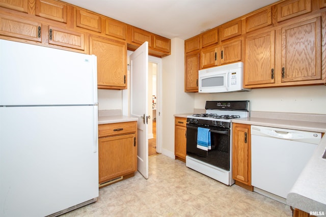 kitchen featuring white appliances, light countertops, and light floors