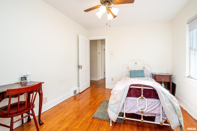 bedroom with baseboards, visible vents, and light wood finished floors