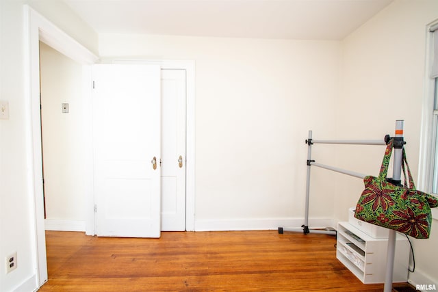 interior space with baseboards and wood finished floors