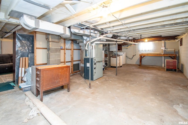 below grade area with heating unit and washer / clothes dryer