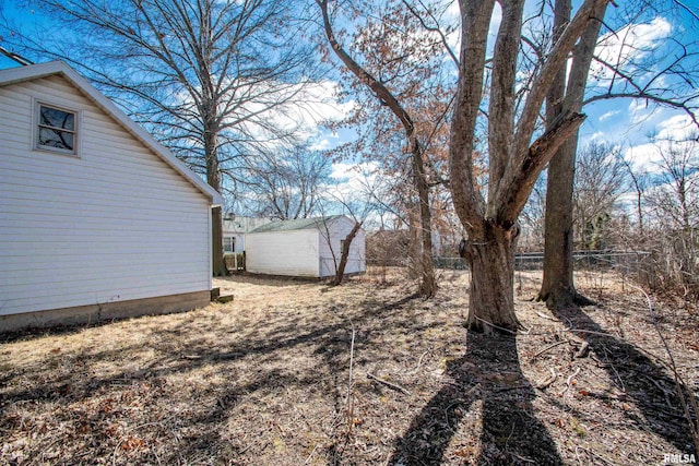 view of yard with fence and an outbuilding