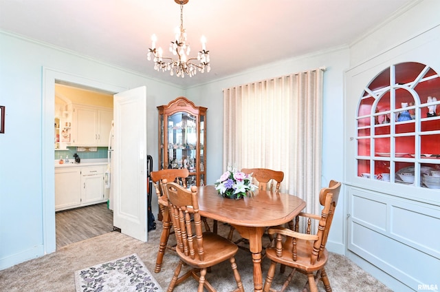 dining area featuring ornamental molding, light colored carpet, and a notable chandelier