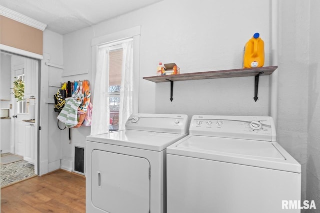 laundry room featuring laundry area, light wood-style floors, and washer and clothes dryer