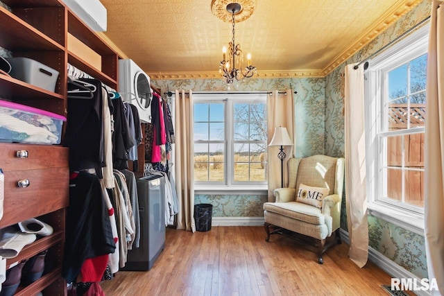 sitting room featuring an ornate ceiling, hardwood / wood-style floors, an inviting chandelier, wallpapered walls, and baseboards