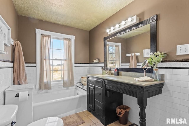 bathroom with tile patterned floors, a textured ceiling, and tile walls