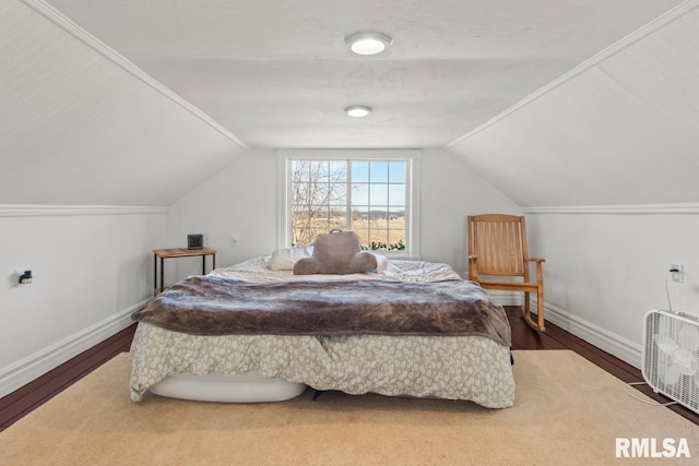 bedroom featuring baseboards, lofted ceiling, and wood finished floors