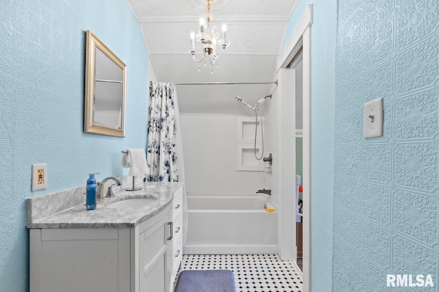 full bath with shower / bathtub combination with curtain, vanity, and a textured wall