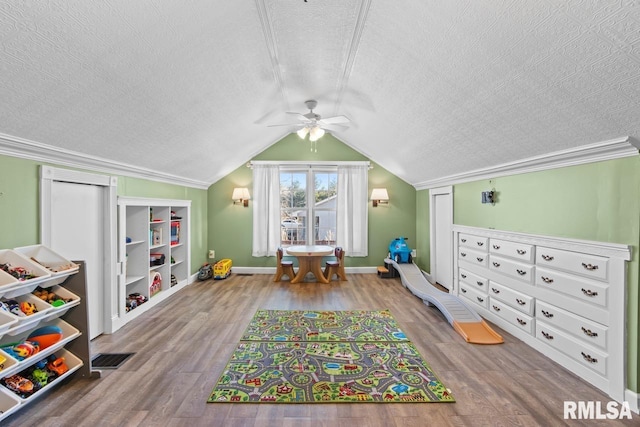 playroom with visible vents, a textured ceiling, wood finished floors, and vaulted ceiling