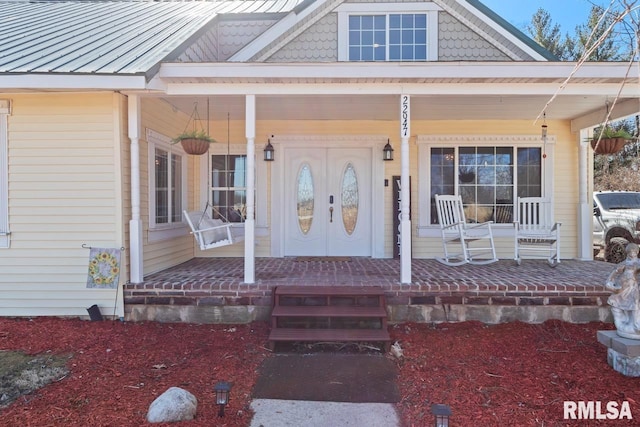 property entrance featuring metal roof, covered porch, and a standing seam roof