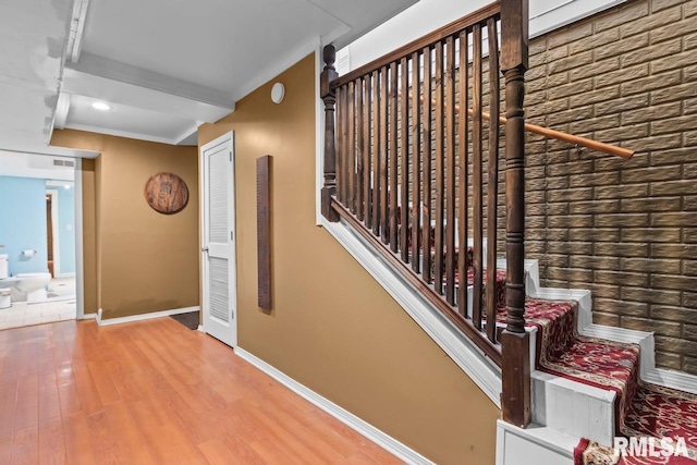 hall with stairs, baseboards, and wood finished floors