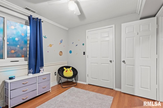 bedroom with light wood finished floors, visible vents, baseboards, and ceiling fan