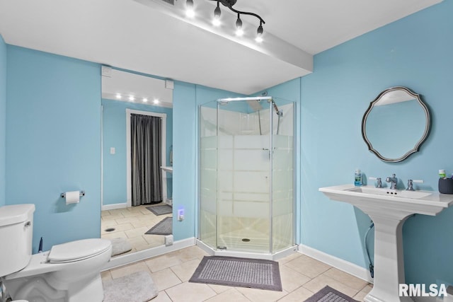 full bath with a shower stall, toilet, baseboards, and tile patterned floors