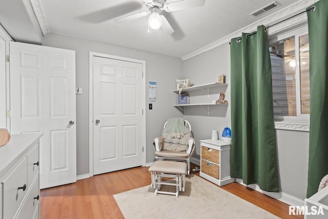 sitting room featuring visible vents, baseboards, light wood-type flooring, and ceiling fan