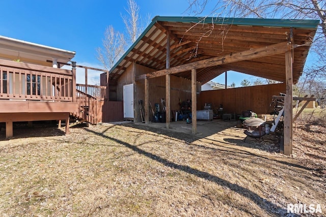 exterior space with a carport, a deck, an outdoor structure, and a pole building