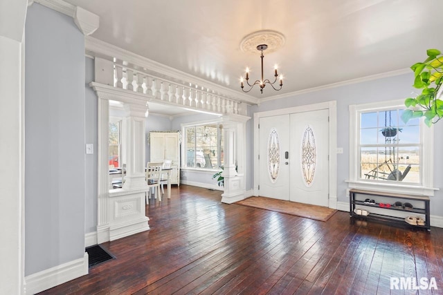 entrance foyer featuring visible vents, ornamental molding, hardwood / wood-style floors, an inviting chandelier, and baseboards