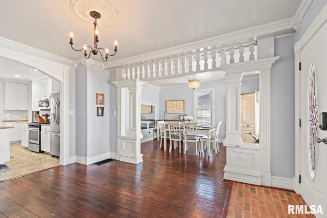 dining room with baseboards, an inviting chandelier, crown molding, and ornate columns