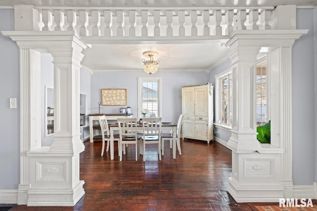 dining room featuring crown molding, wood finished floors, and ornate columns