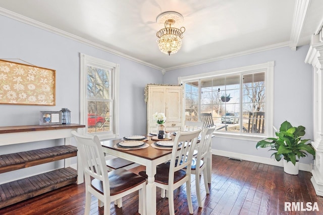 dining room featuring visible vents, baseboards, ornamental molding, an inviting chandelier, and hardwood / wood-style flooring