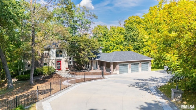 view of front facade with a garage, concrete driveway, and fence