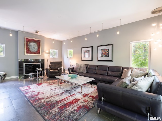 living room featuring a glass covered fireplace and baseboards