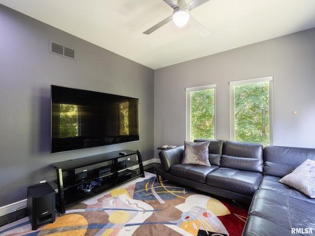 living room featuring a ceiling fan, visible vents, and baseboards