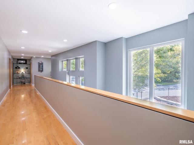 hallway with light wood-style flooring, baseboards, and recessed lighting