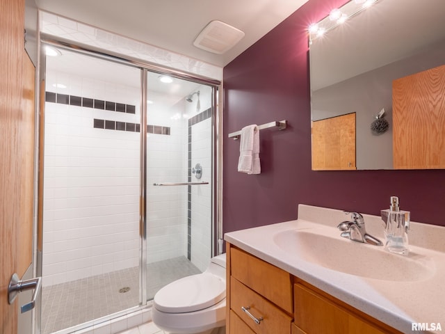 bathroom featuring visible vents, a shower stall, toilet, and vanity