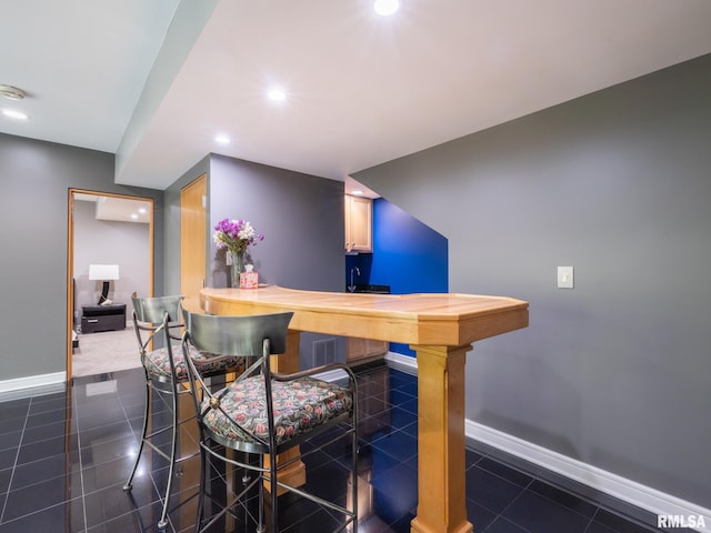 bar featuring baseboards, dark tile patterned flooring, and recessed lighting