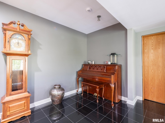 sitting room featuring baseboards and dark tile patterned flooring