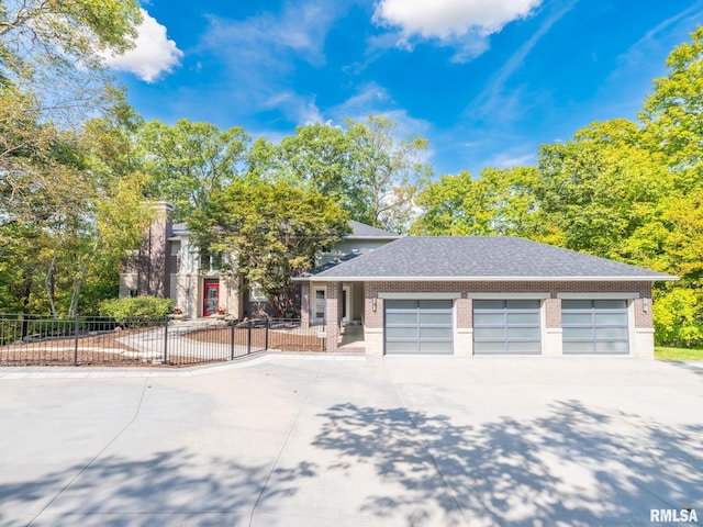 prairie-style home featuring an attached garage, a shingled roof, brick siding, fence, and concrete driveway