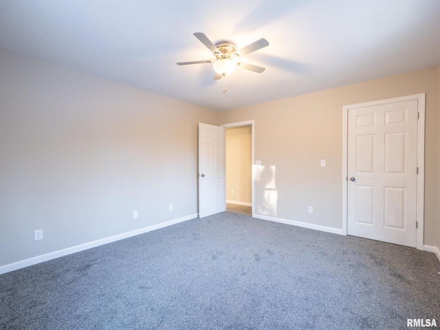 carpeted empty room with a ceiling fan and baseboards