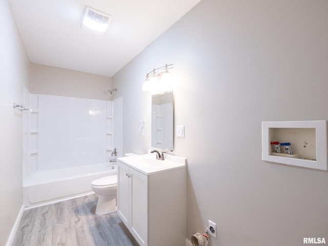 full bath featuring wood finished floors, bathing tub / shower combination, vanity, and toilet
