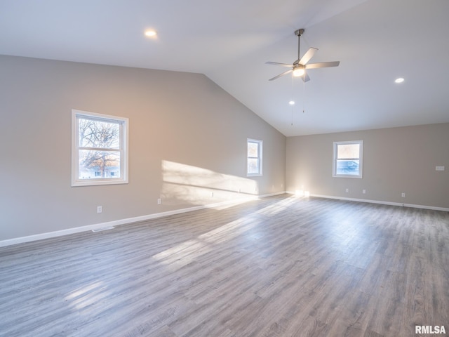 empty room with a ceiling fan, vaulted ceiling, baseboards, and wood finished floors