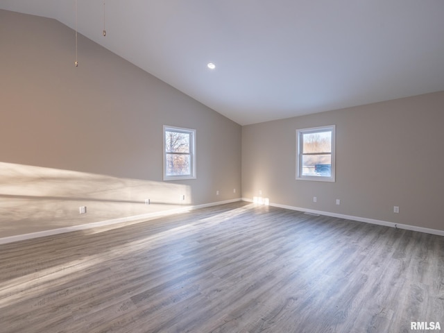 unfurnished room with high vaulted ceiling, baseboards, a wealth of natural light, and wood finished floors