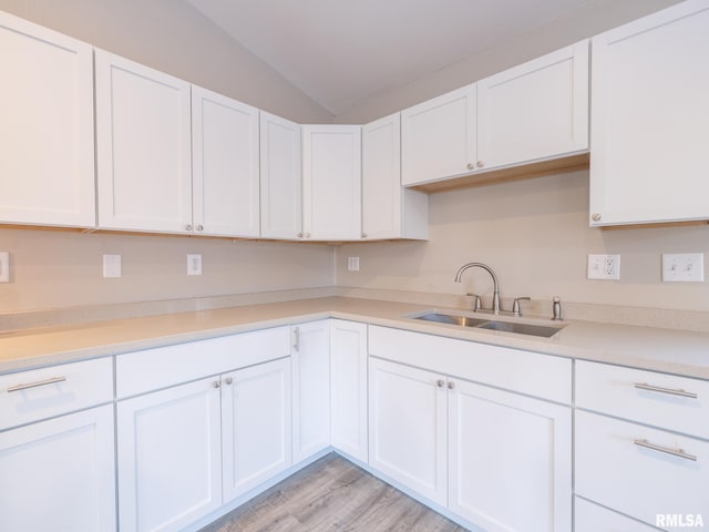 kitchen featuring light countertops, white cabinets, and a sink