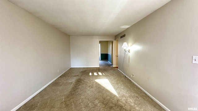 unfurnished room featuring carpet, visible vents, and baseboards