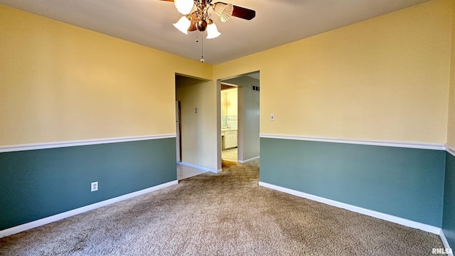 spare room with carpet floors, baseboards, and a ceiling fan