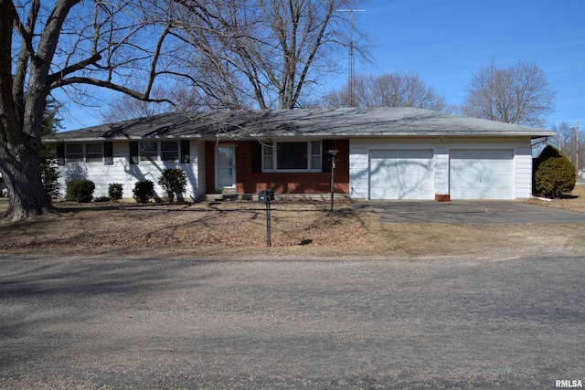 ranch-style house with a garage, driveway, and brick siding