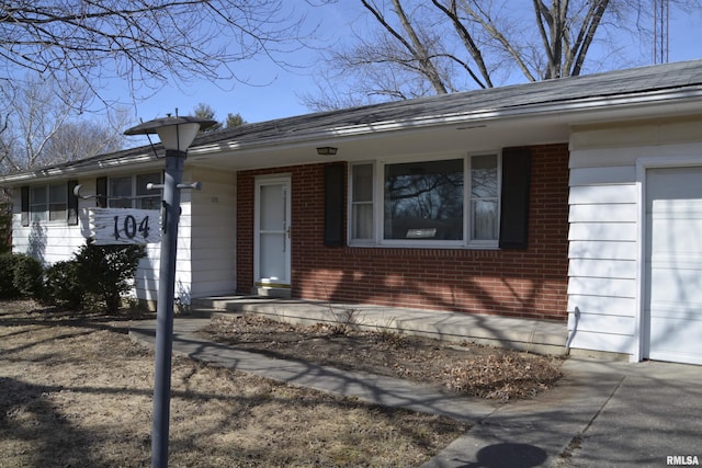 entrance to property featuring brick siding and an attached garage