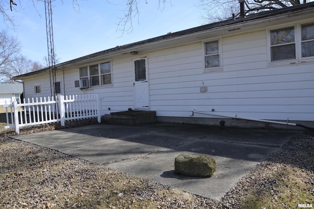 rear view of house featuring entry steps, a patio, and fence