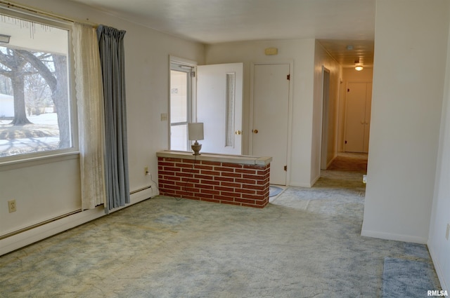 carpeted empty room with a baseboard radiator and baseboards