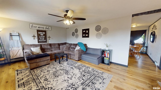 living area featuring ceiling fan, baseboards, and wood finished floors