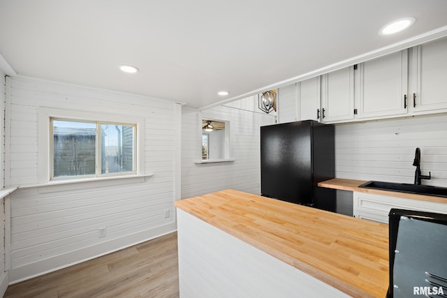 kitchen featuring wood finished floors, freestanding refrigerator, wooden counters, a sink, and recessed lighting