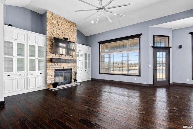 unfurnished living room featuring hardwood / wood-style floors, plenty of natural light, a stone fireplace, and high vaulted ceiling