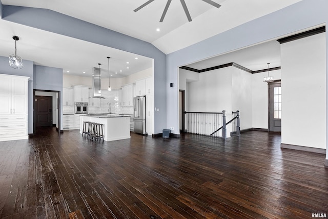 unfurnished living room featuring recessed lighting, lofted ceiling, baseboards, dark wood-style flooring, and ceiling fan with notable chandelier