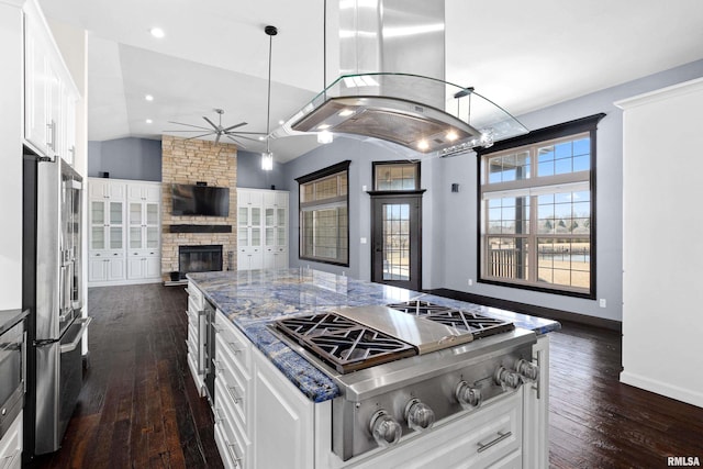 kitchen with a ceiling fan, open floor plan, island exhaust hood, lofted ceiling, and appliances with stainless steel finishes