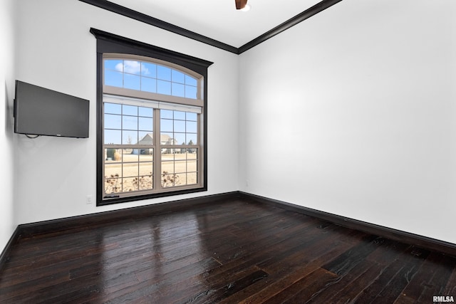 empty room with baseboards, ornamental molding, and dark wood finished floors