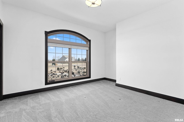 carpeted spare room with baseboards